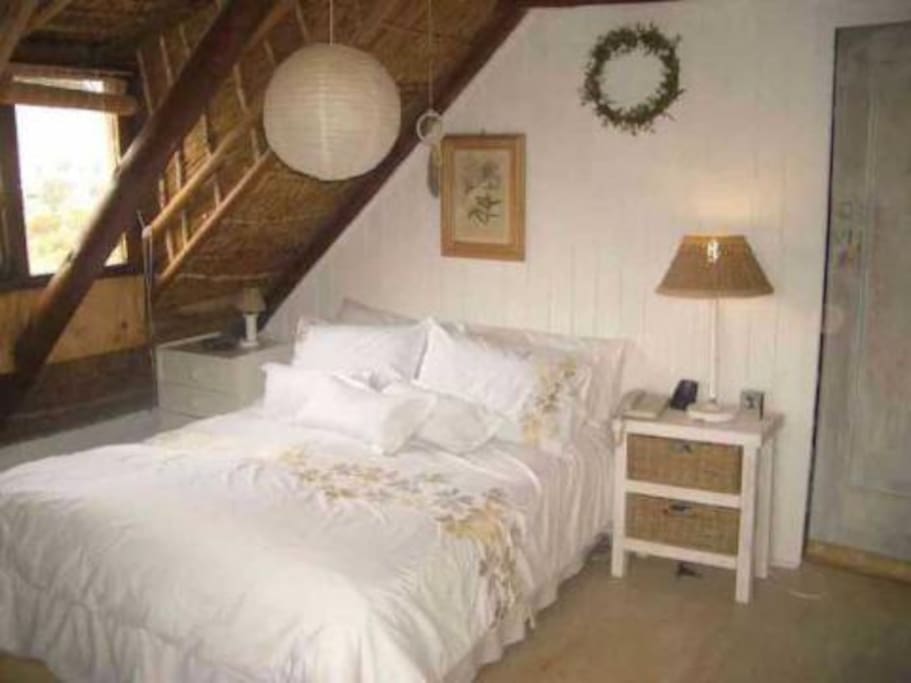 Secluded cozy upstairs bedroom , exposed thatch ceiling, With TV.