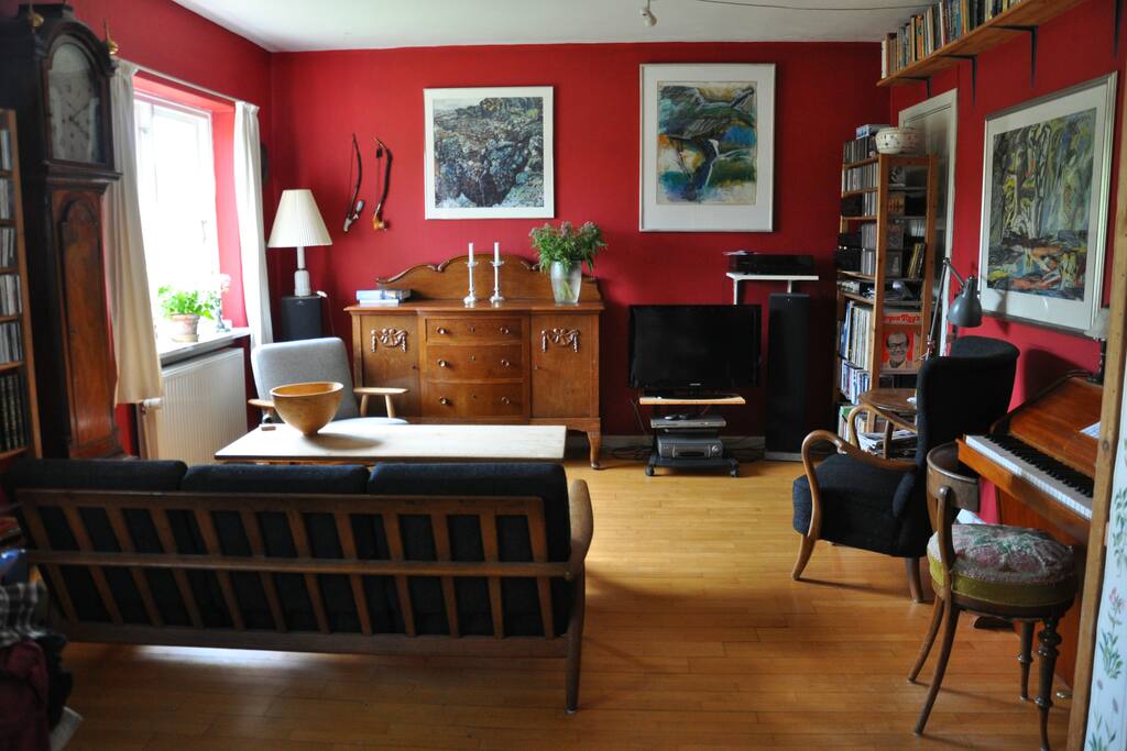 Living room with couch, armchairs and a small piano