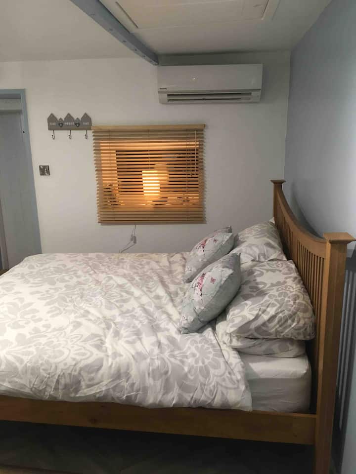 Dvojposteľová strana postele ukazuje klimatizáciu a vchod do okna. 