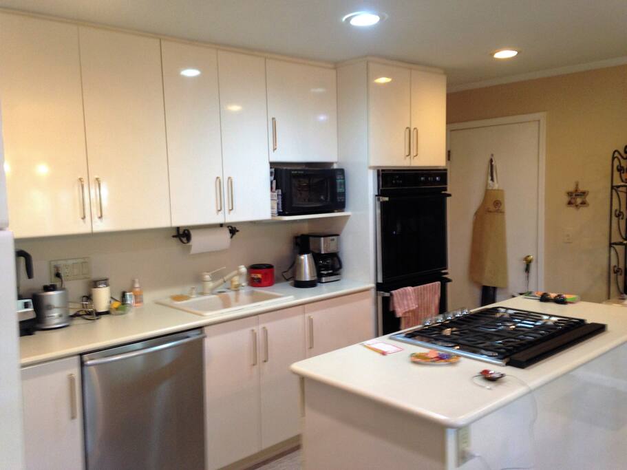 Clean, sleek kitchen with JennAir refrigerator, Viking cooktop, center island.