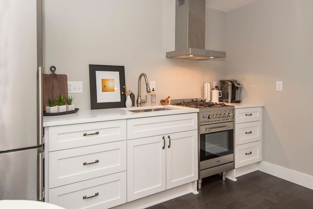Modern kitchen with quartz counters, soft close cabinets and dual fuel gas range!