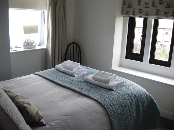 Dvojposteľová spálňa s pôvodnou edvardovskou manželskou posteľou. Izba s výhľadom na susednú záhradu domu a príjazdovú cestu. 