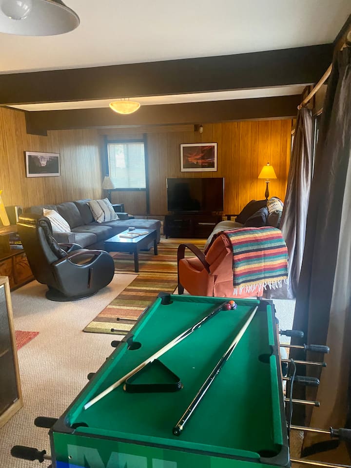 Chumba cha mchezo wa kiwango cha chini/chumba cha kulala #3 -  na bafu ya kibinafsi, sofa mpya ambayo inabadilika kuwa kitanda kamili, foosball, michezo, TV na ufikiaji wa moja kwa moja kwa nje.