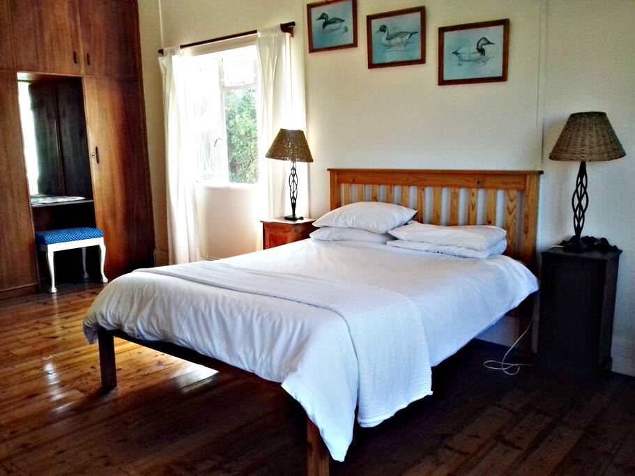 The main bedroom with queen sized bed and door leading onto balcony
