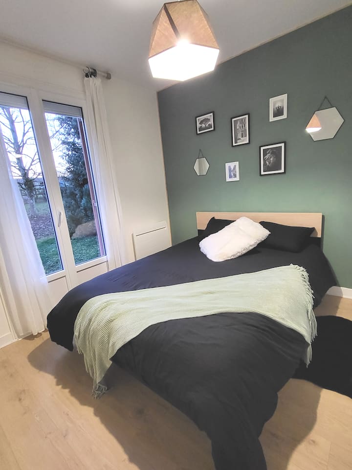 Chambre avec lit de 140cm et rangement. Accès à une terrasse extérieure. 