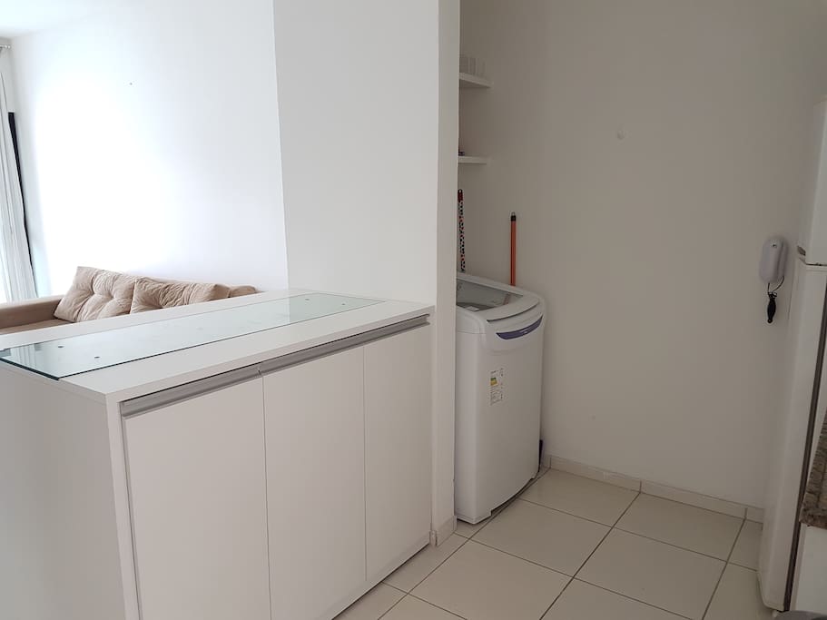 Cozinha com mesa de apoio para refeições rápidas e área de serviço.