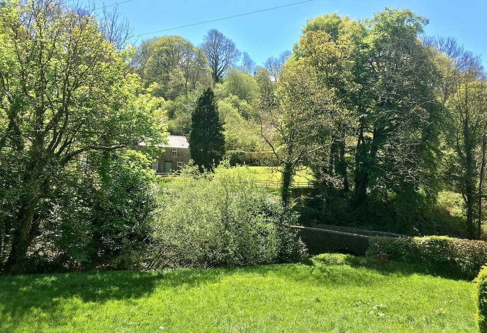 Cottage is nestled in picturesque valley overlooking stone bridge.