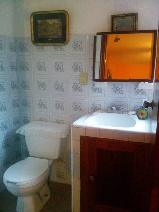 El medio baño está fuera de la habitación pero está disponible para los huéspedes.