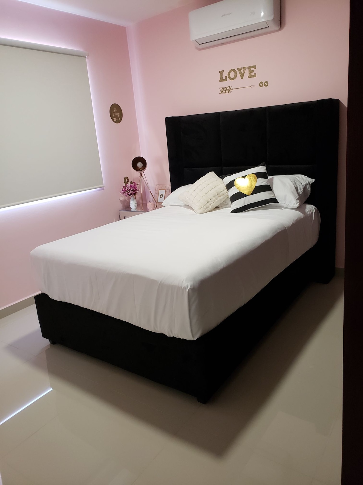 Spálňa  s manželskou posteľou a písacím stolom, ručnou lampou, plachtami a vankúšmi.