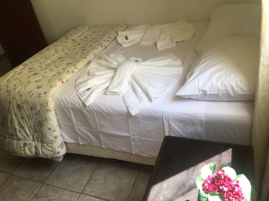 Quarto com cama de casal, armário, ar condicionado e ventilador de teto.