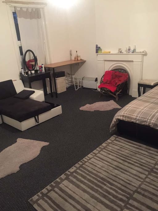 A small table, a small vanity table, a chair, and a space heater.
