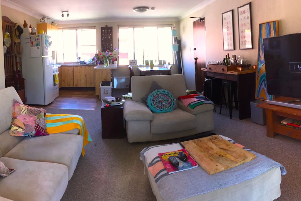 Sunny living area with windows on both sides for the afternoon breeze. HUGE TV with surround sound and wifi so you can log into NETFLIX