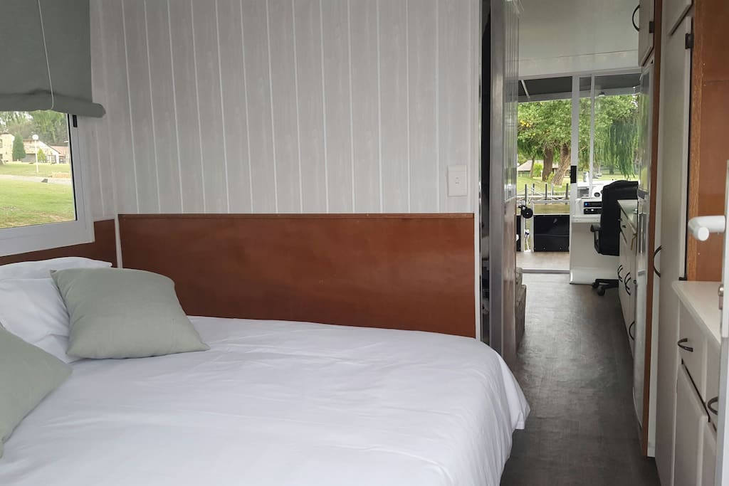 Bedroom with queen size bed and cupboards.