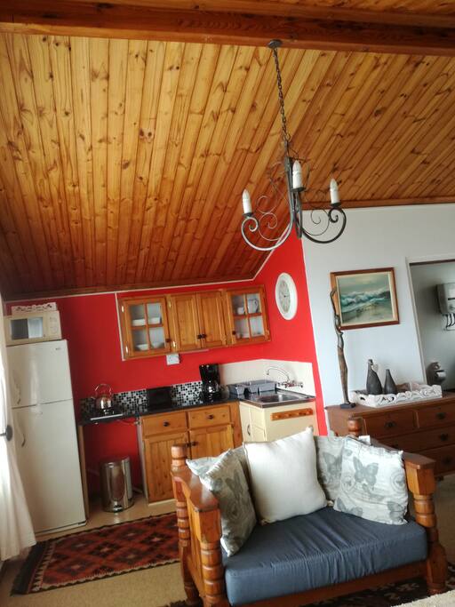 Open plan kitchen with build in two plate gas hob, microwave, fridge/refrigerator, cofee perculator and toaster.