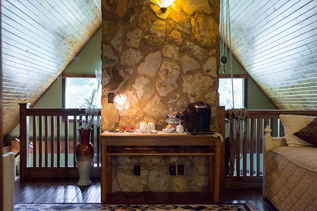 Loft area of the room that contains coffee maker and small icebox