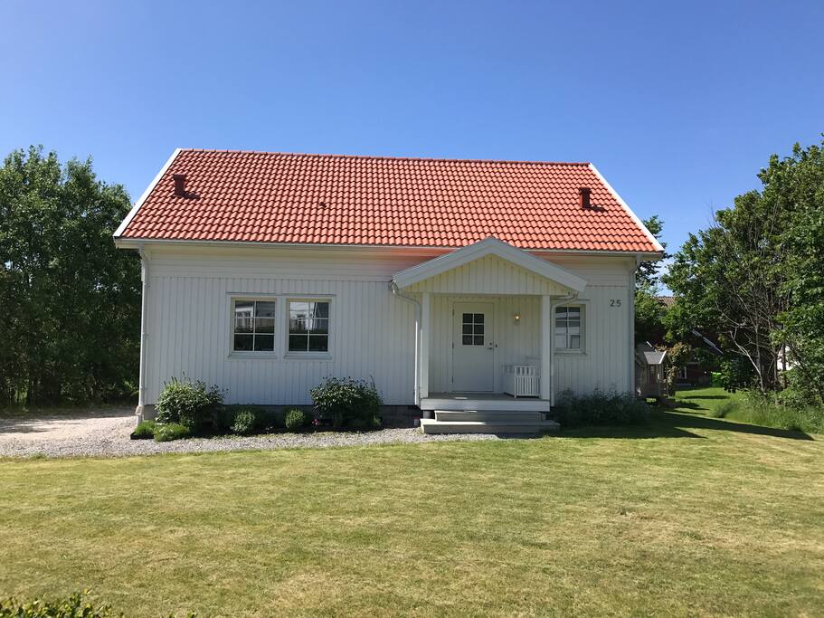 Huset från framsidan med stora trädgårdsytor.