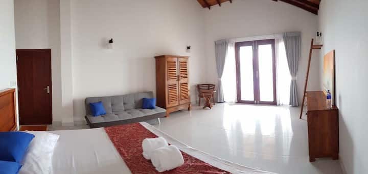 キングサイズのベッドと追加のソファベッドを備えたベッドルーム。オーシャンビューとバルコニー 