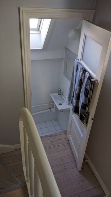Dele toilet/håndvask på 1. sal med et andet værelse.