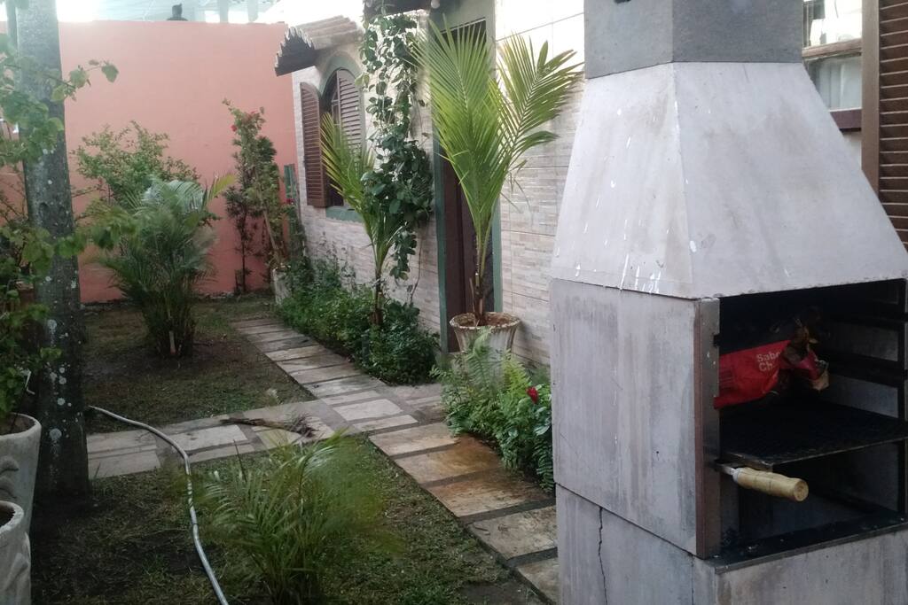 Jardim e churrasqueira na entrada da casa