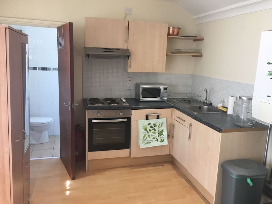 A full kitchen with a fridge, and washer under the microwave.