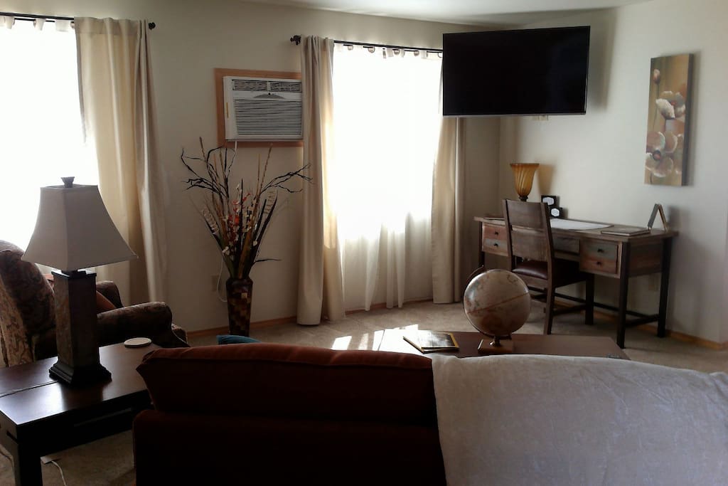 Your private living room with tv and desk.