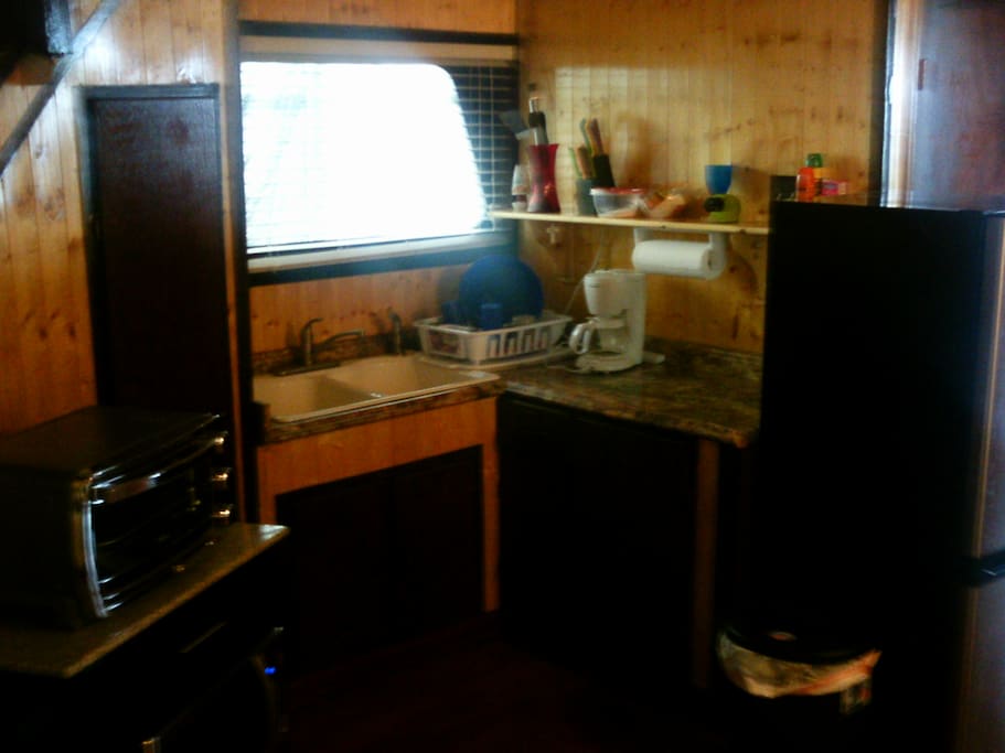 Kitchen area equipped with microwave, coffee pot, toaster oven, and refrigerator