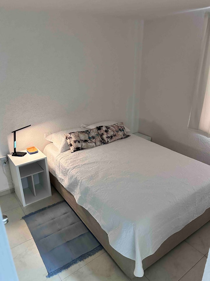 Double bed, two light-toned, wireless cell phone charger; one-door closet equipped with ironing board, mirror, and a banquite to use the open part of the closet as a vanity.