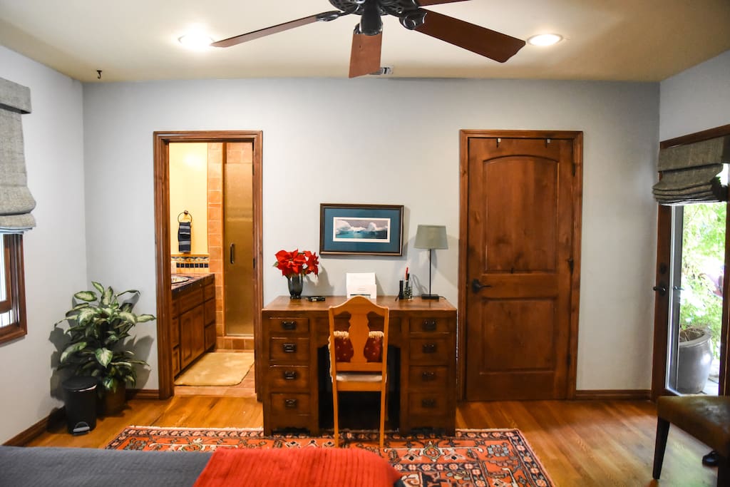 Doors to private bath with shower on left and to walk-in closet on the right of desk.