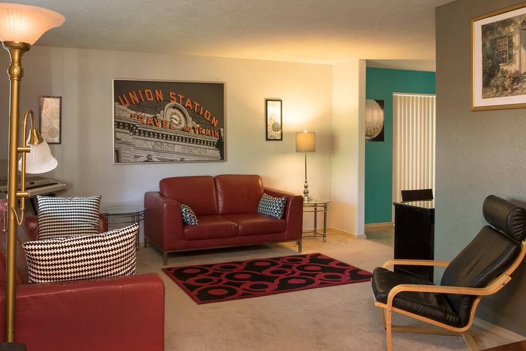 The LR is comfortably furnished with sofas, a wall-mounted flat-screen TV and a piano.