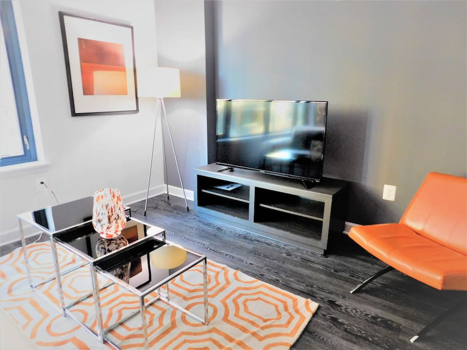 Pops of orange liven up the space. Oh, and that Smart TV you see helps.