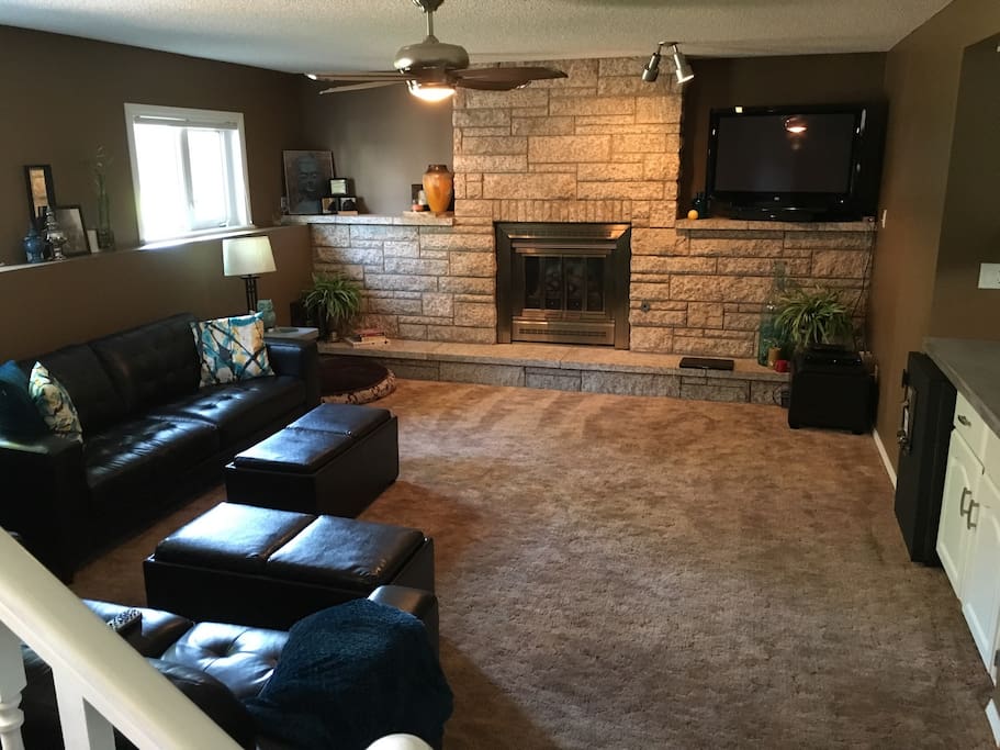Guest living room / den area with satellite tv and Apple TV. Also has mini wet bar and private mini fridge. Flows down from shared kitchen. 1 queen bedroom and full bathroom.
