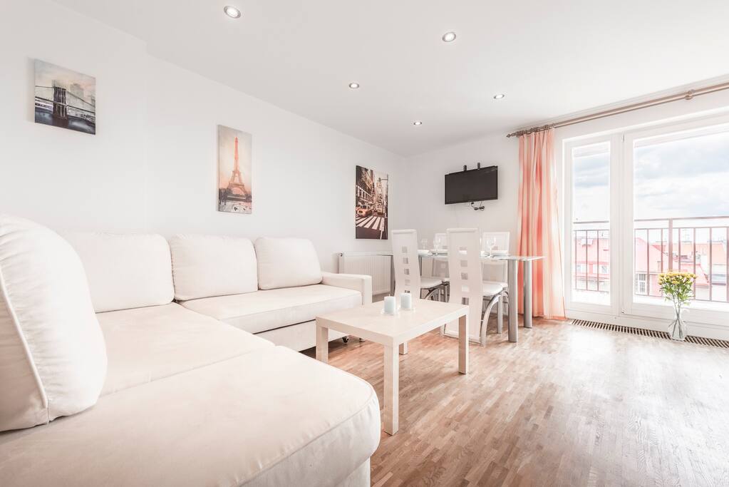 Living room with foldable sofa & TV with entrance to terrace.