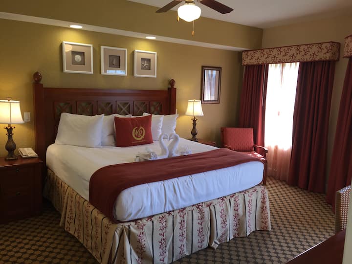 Kingsize bed in de slaapkamer met aan de muur gemonteerde flatscreen-tv.