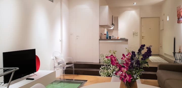 Sala de estar con entrada y medio baño con puerta a pared