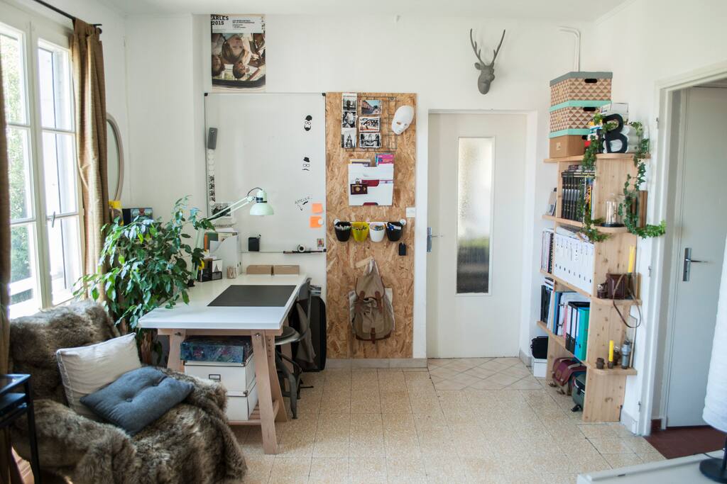 Deuxième partie du salon avec une bibliothèque pour se plonger dans un livre sur le fauteuil ou travailler sur le bureau face à la fenêtre.