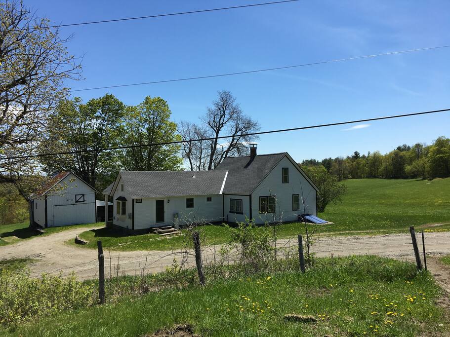 Farmhouse view from orchard across dirt road
