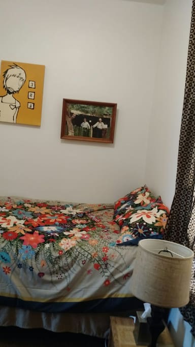 This is the guest room. It's small but cozy, with a full-sized bed, colorful bedding and art!