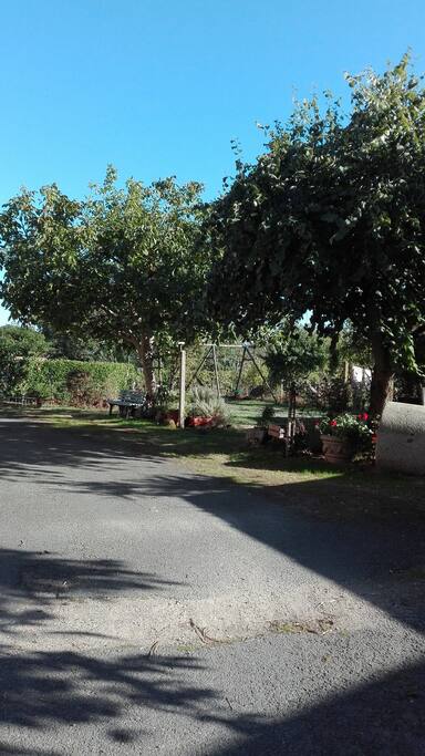 Jardin fermé avec ombrage et jeux pour les enfants.