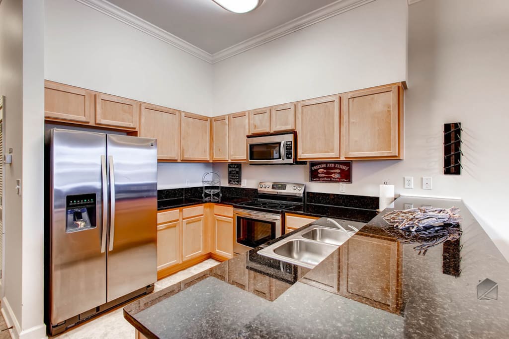 This modern kitchen has granite countertops and everything you'll need to cook a great meal which features a stainless steel refrigerator and ice dispenser.