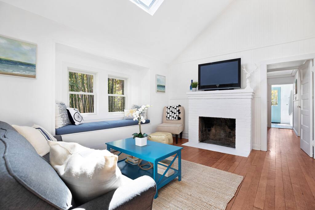 The living area features comfortable seating, vaulted ceilings, a flatscreen TV, and a fireplace.