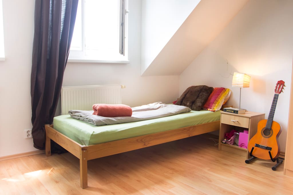 Man's bed under the bright sky window with thick curtains to provide restful darkness
