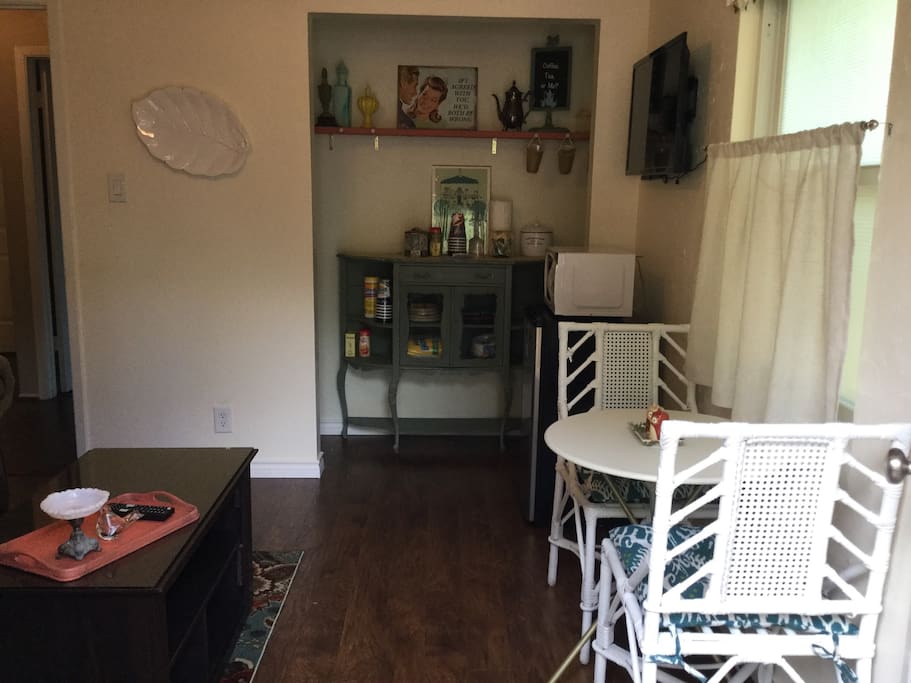 Main entry living area with Coffee/Tea bar, fridge, microwave, dining/work table, comfy loveseat and tv.