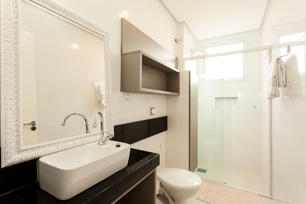 Banheiro com lavabo, sanitário e box em blindex