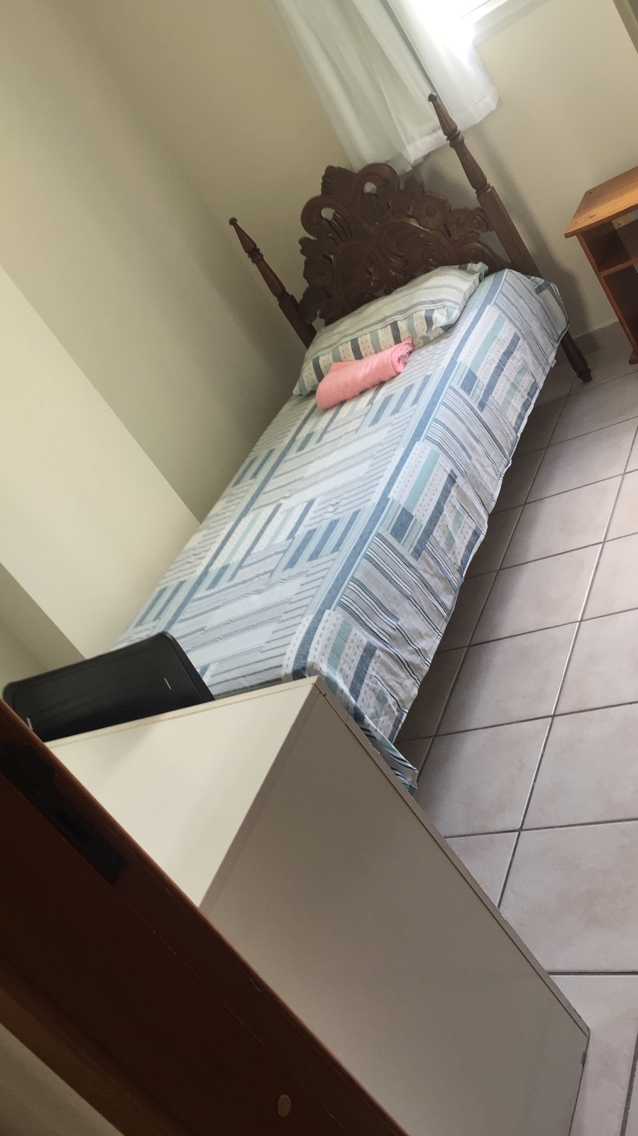 Single room with bed, wardrobe, ceiling fan, white curtain with black-out , table , chair and stool. 