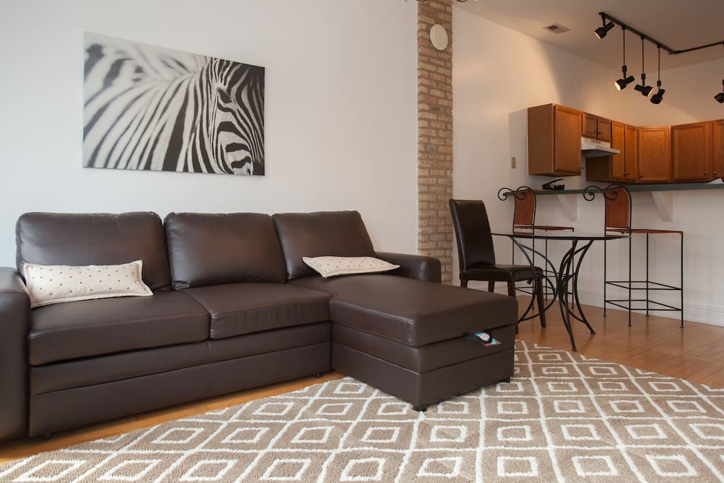 Linens for this pull out couch are stored inside of the chaise lounge that lifts like a car hood.
