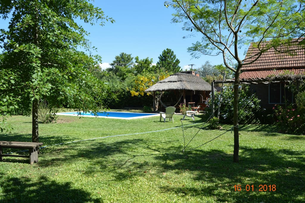 jardin , avec piscine , barbecue et four à pizza.