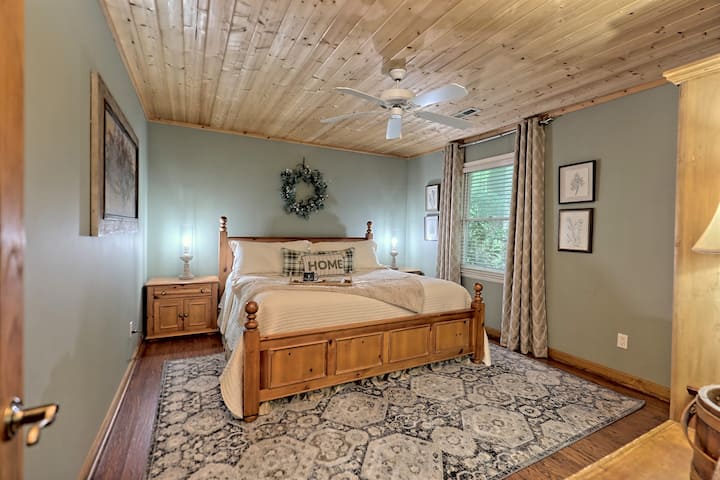 ห้องนอนหลักในเกสต์เฮาส์มีเตียงคิงไซส์โต๊ะข้างเตียงคู่และตู้เสื้อผ้า 