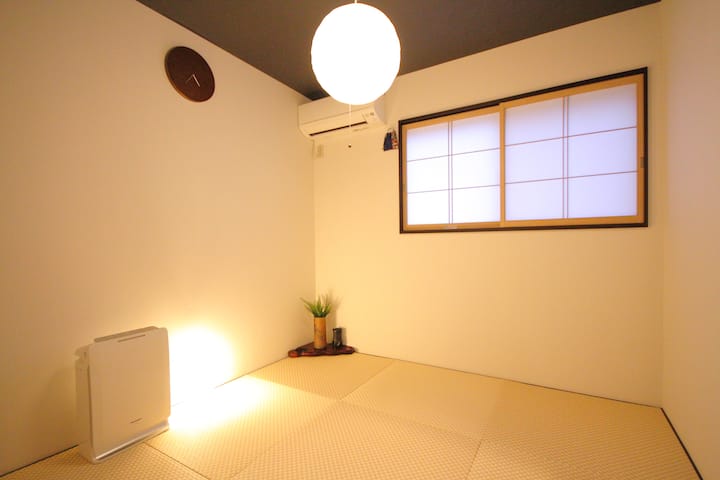 白い壁面の明るい和室もご用意致しました。黒い天井で引き締まったモダンな印象で、木材の美しい掛け時計を配しました。