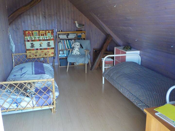Chambre n°3  avec deux lits simples, livres et jeux pour enfants