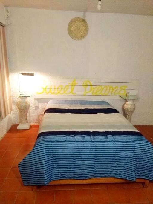 Cama matrimonial y lampara de lectura.